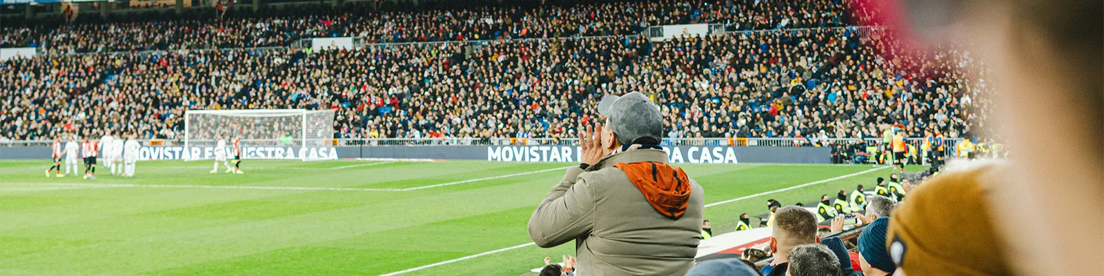 Torcedores de futebol no estádio vibrando, ilustrando a paixão que move o site Futebol24h - jogos ao vivo, horários e onde assistir.
